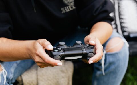 Close-up of hands holding a video game controller, showcasing leisure and gaming indoors.