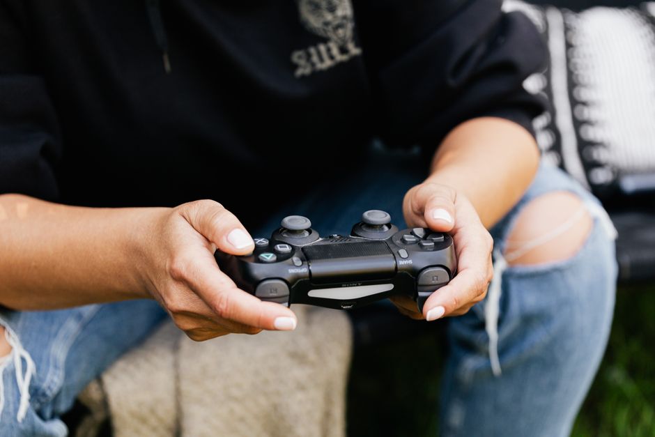 Close-up of hands holding a video game controller, showcasing leisure and gaming indoors.