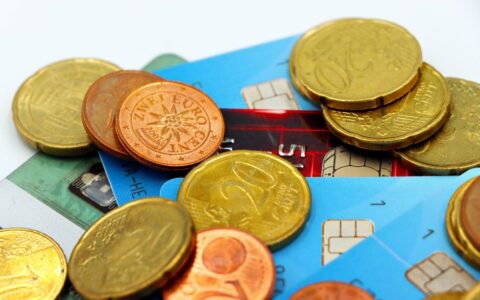 Close-up image of Euro coins and credit cards representing modern financial transactions.
