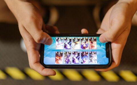 Close-up of hands playing a mobile game on a smartphone, showcasing the game's interface.