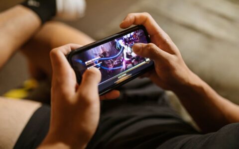 A person playing a mobile video game on a smartphone, focusing on gaming and technology lifestyle.