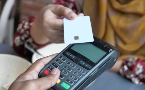 Close-up of a contactless credit card payment being made at a store terminal.