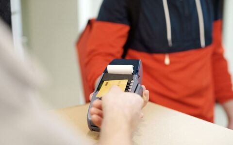 Close-up view of a contactless payment transaction using a credit card on a terminal device.